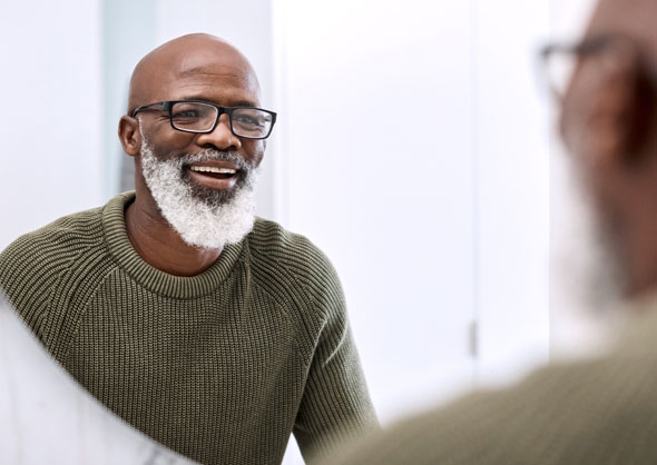 Older man looking at smile in mirror